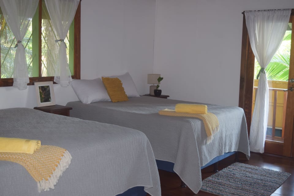 Bedroom on main floor with 2 queen beds, private entrance to bathroom & balcony.