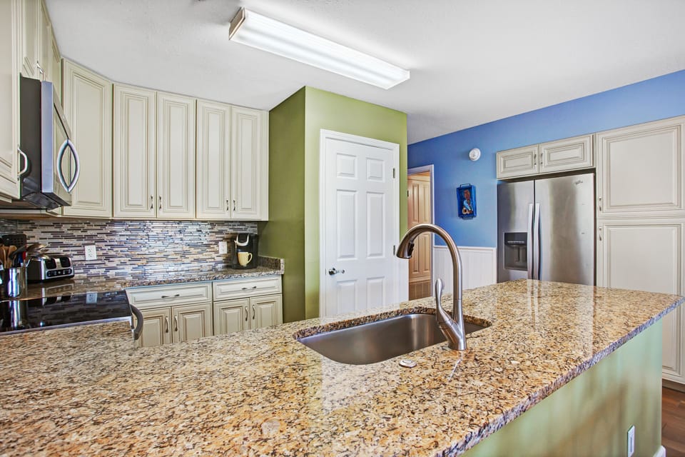 Kitchen is well-equipped with glasses, dishes, cookware and utensils