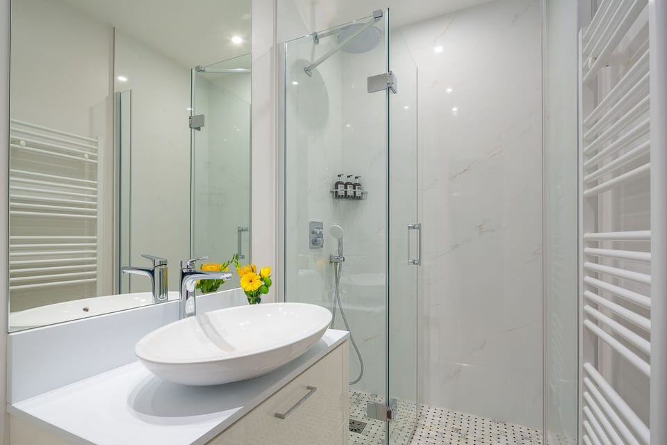 Bathroom 1 has a large shower and sink.