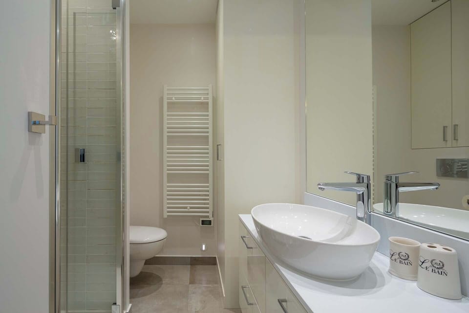 En suite in bedroom 2 has with a shower, toilet, sink and storage.