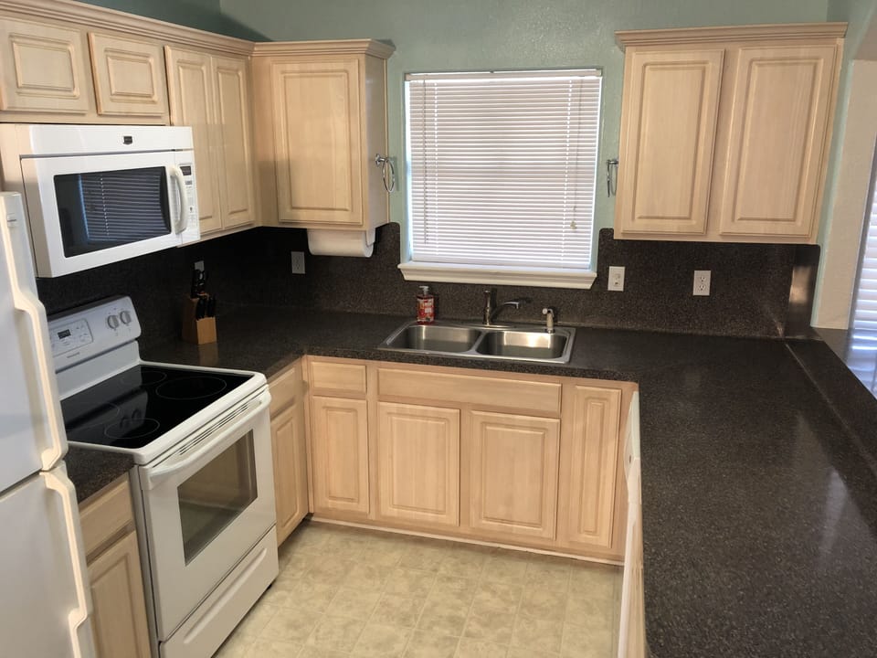 Kitchen with plenty of amenities and view of the beach and deck from window