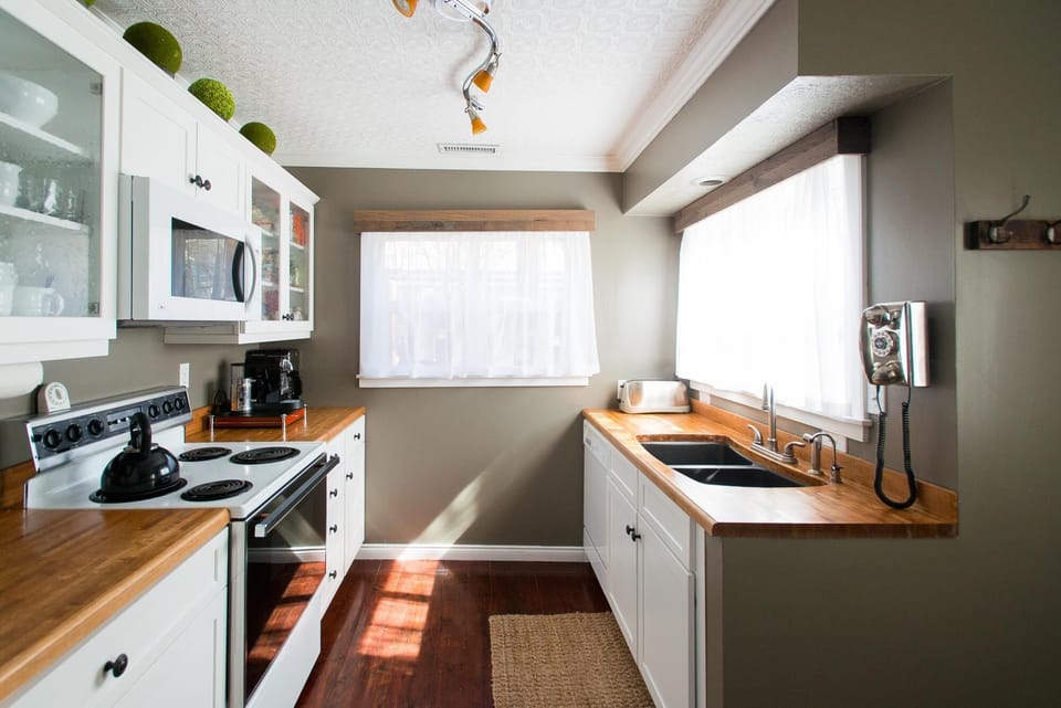 Kitchen with stocked cupboards & utensils, Nespresso machine and coffee maker.