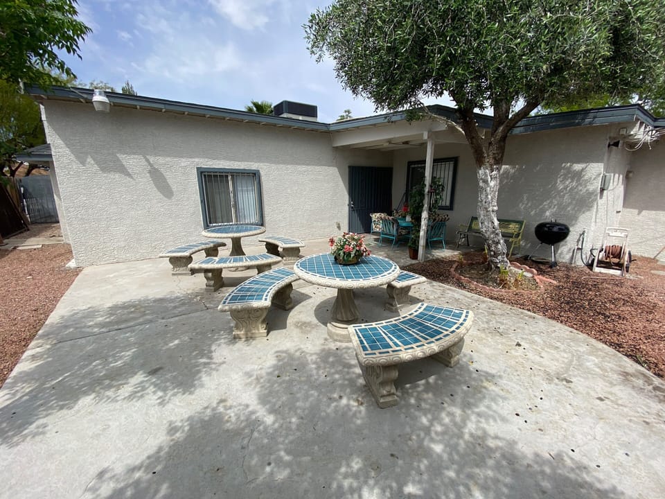 Backyard with outdoor furniture, charcoal grill, and seating