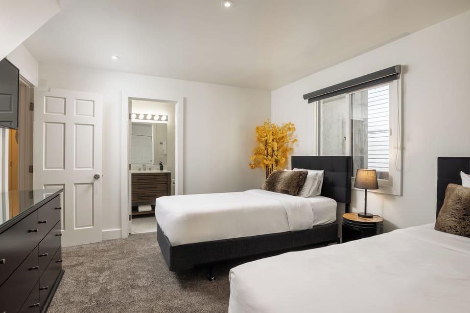 Sink into crisp white linens after a day of adventure. Your private ensuite and cozy bedside lighting make this space perfect for restful nights.