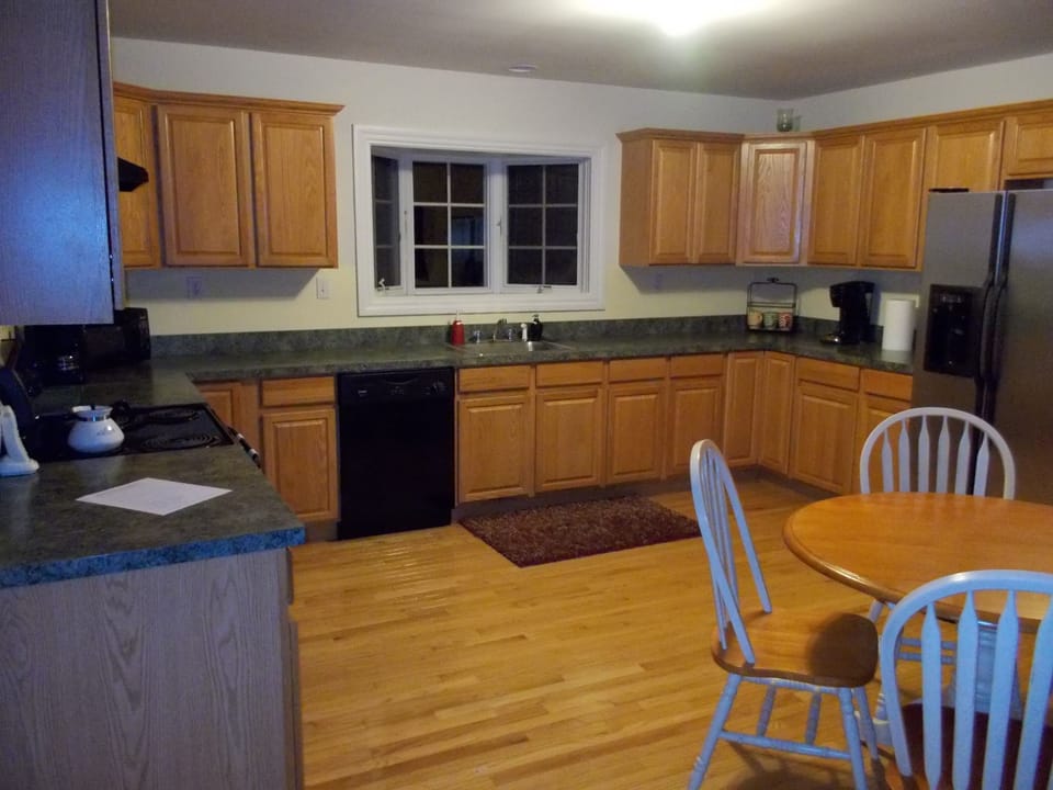 huge kitchen with microwave, dish washer, range, oven, toaster and a table for 4