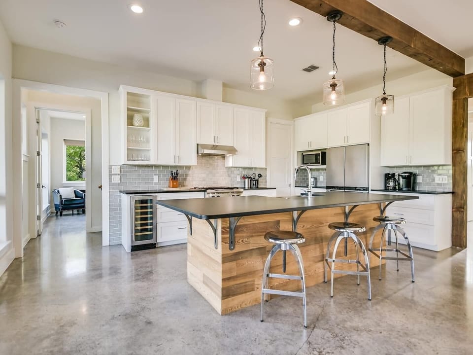 View of kitchen with wine fridge and gas stove.
