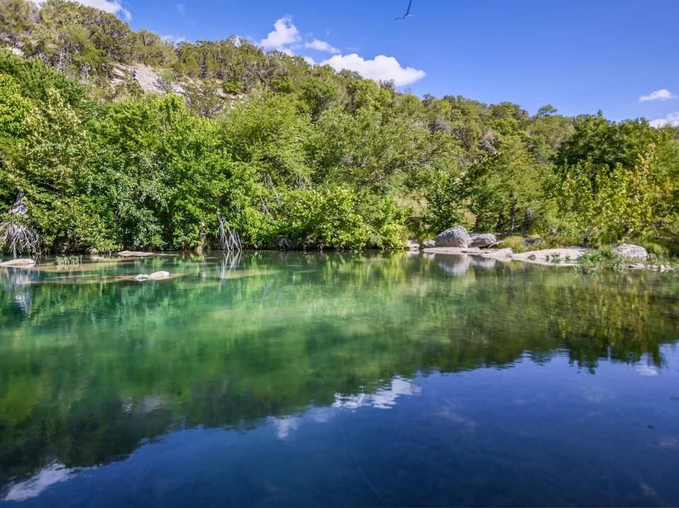 View from our side of the river looking towards the bluff across the river.  Deep water at all times along our 600 feet of the Blanco River and the bluff provides privacy unequaled in other parts of the river.