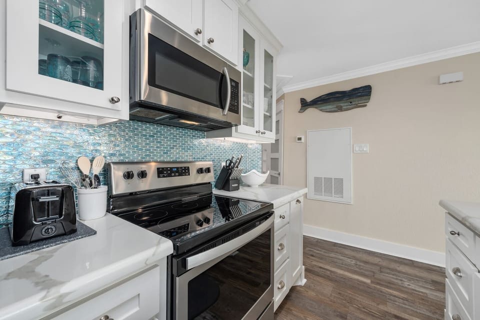 Modern kitchen with a vibrant aqua backsplash, echoing the sea.