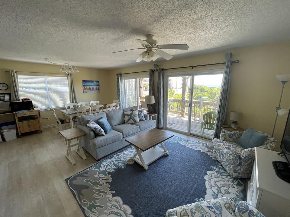 Living area with couches and coffee table. Dining with seating for 8