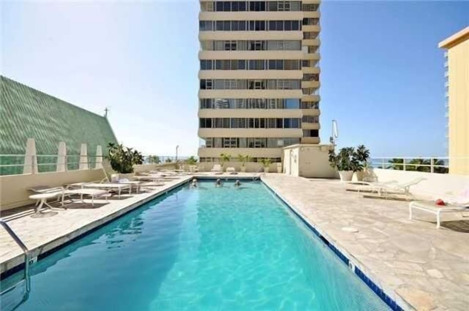 Heated saltwater pool with lounge chairs on 4th floor with ocean and beach view. 