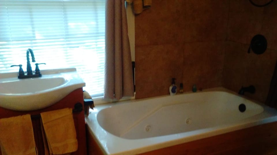 Whirlpool Soaking Bathtub & Vanity next to First Floor Bedroom through archway