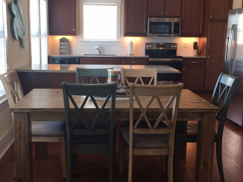 Dining room table for 6, plus 4 stools at the bar.