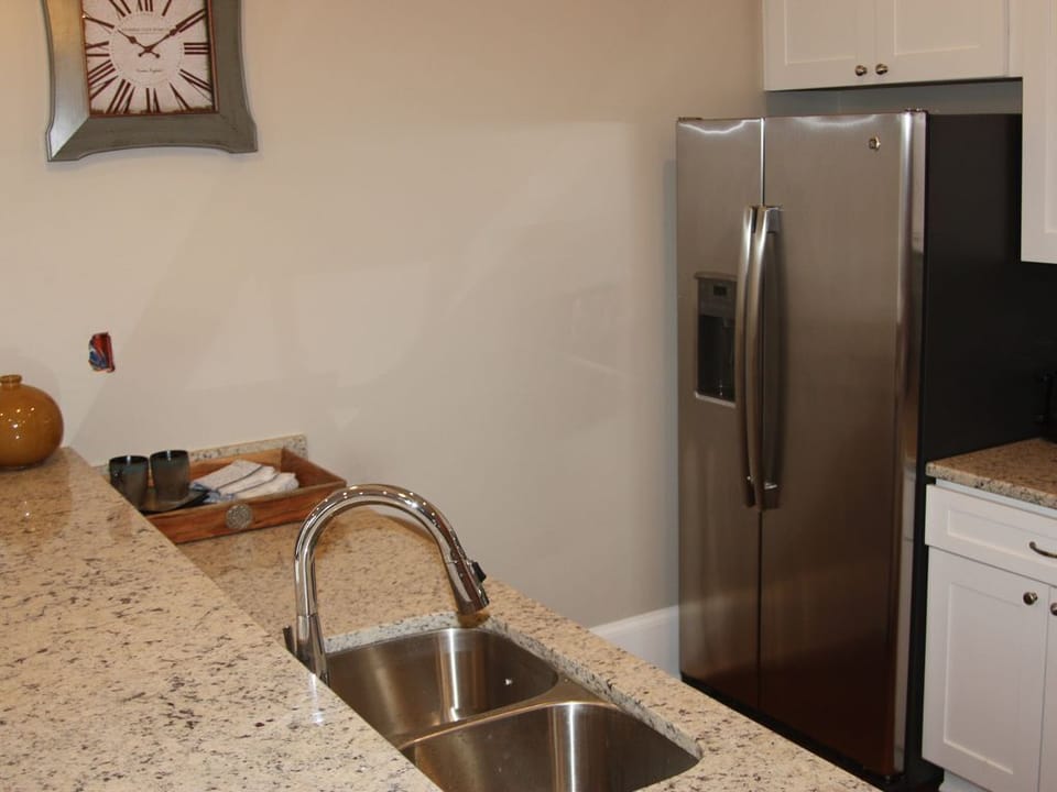 Galley kitchen has breakfast bar seating on the back side of the kitchen sink