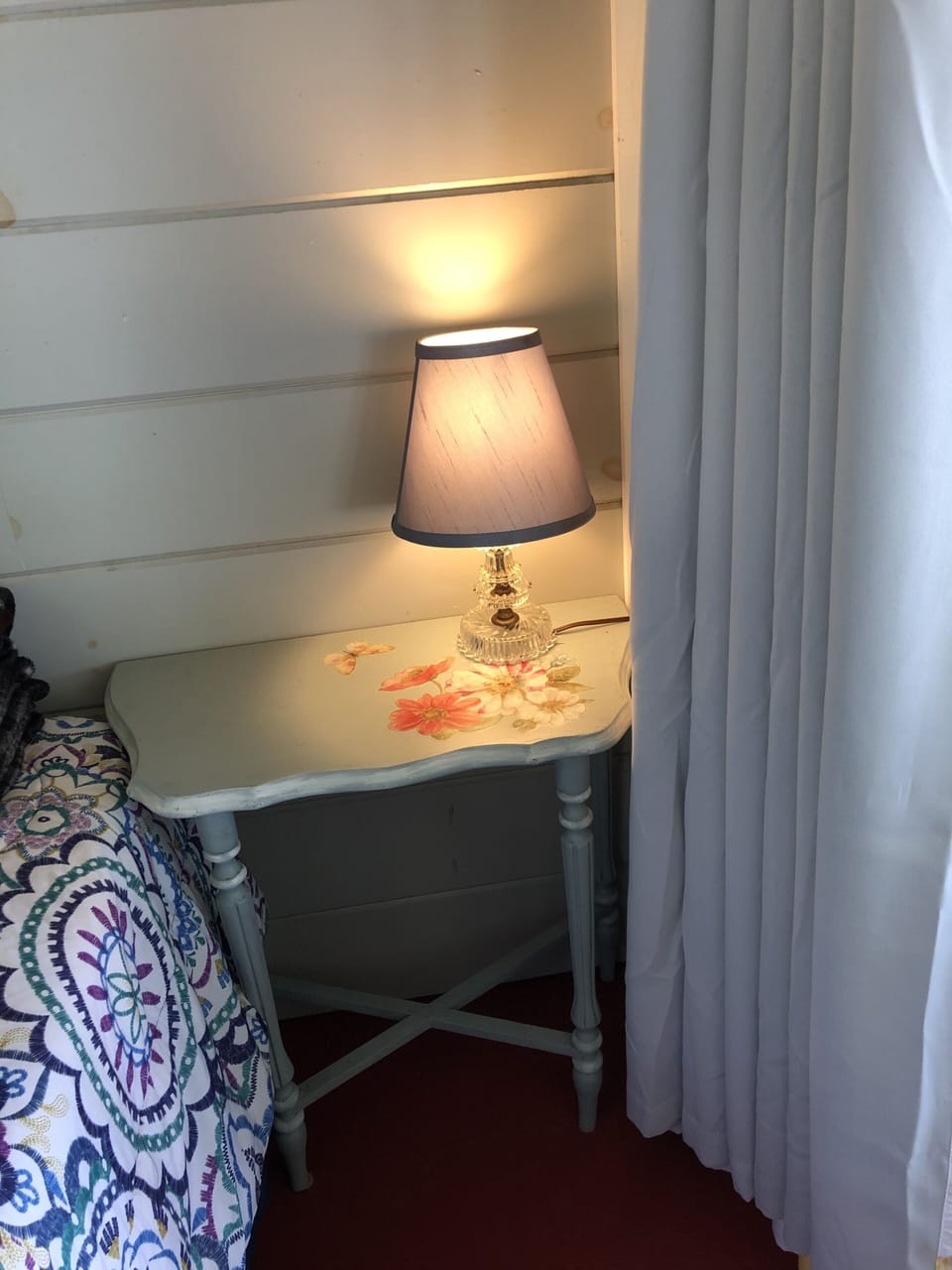 Antique table and lamp in bedroom on porch. 
