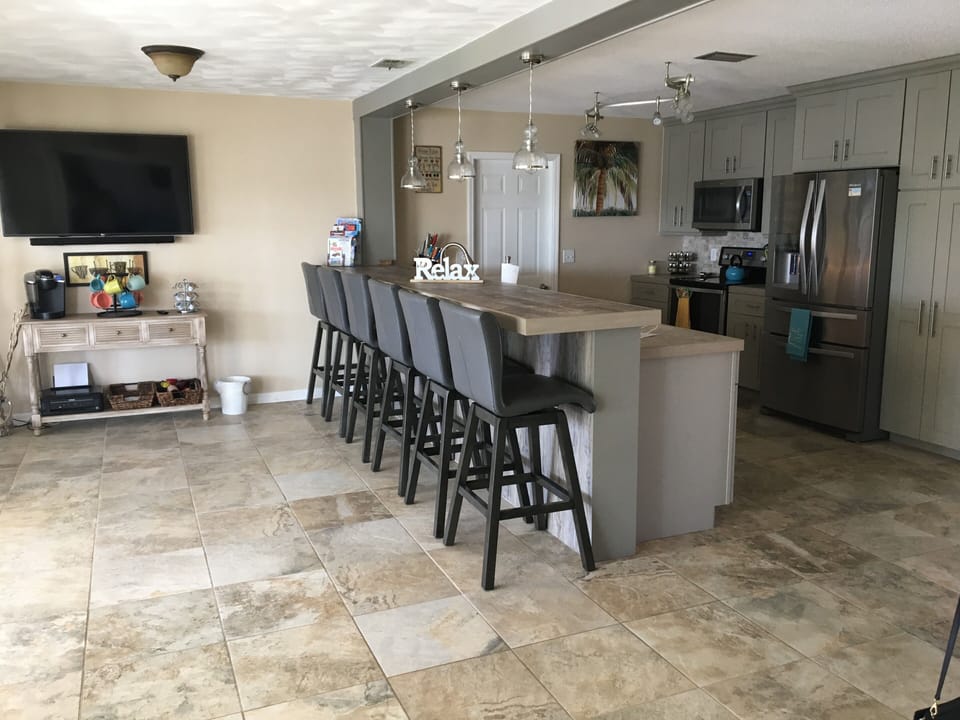 Kitchen with coffee bar and a bar w/seating for 6 and a 55" tv.