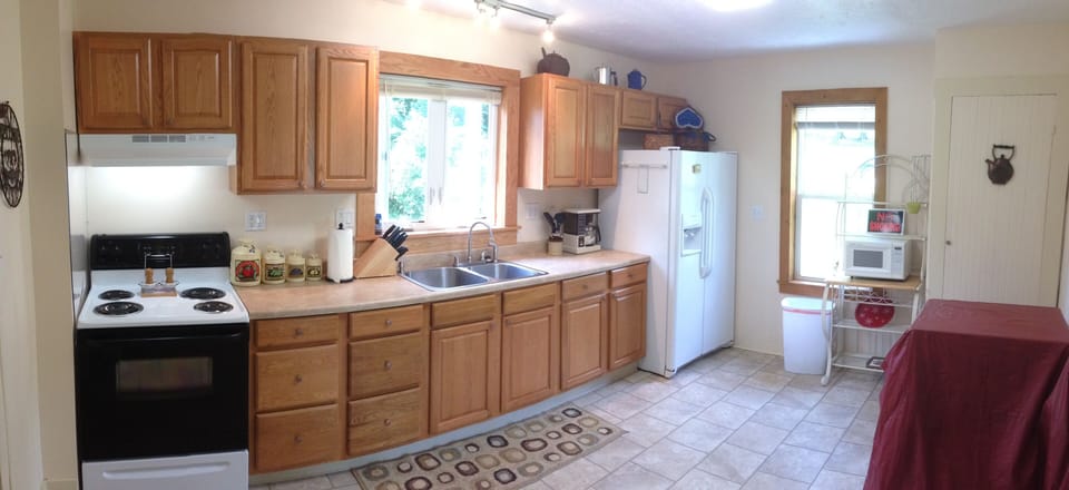 Kitchen includes a large variety of modern cooking utensils and new appliances 