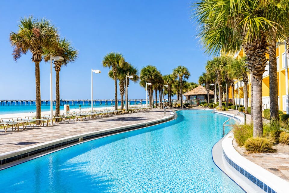 Sparkling pool winds toward pristine turquoise waters and powdery white sand, framed by swaying palms. Your perfect beach escape awaits just steps away.