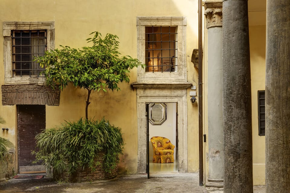 The courtyard entrance of the apartment with the orange tree on the left.