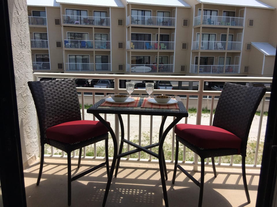 A bar height table with 2 comfortable cushioned chairs for outdoor dining!