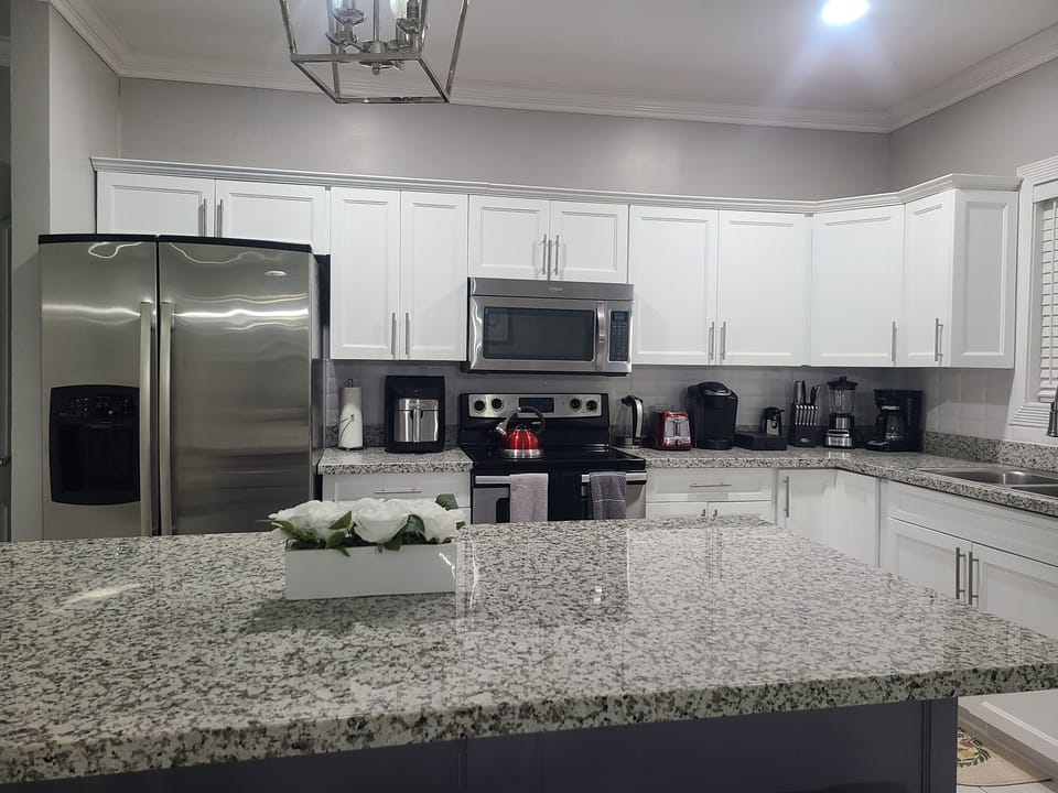 Modern kitchen with appliances including air fryer and coffee maker. 