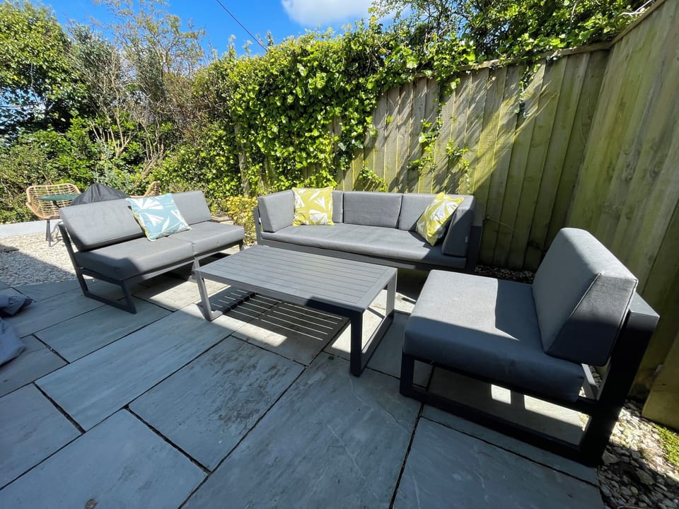 Comfortable seating on garden terrace.  And a warm shower for sandy dogs !