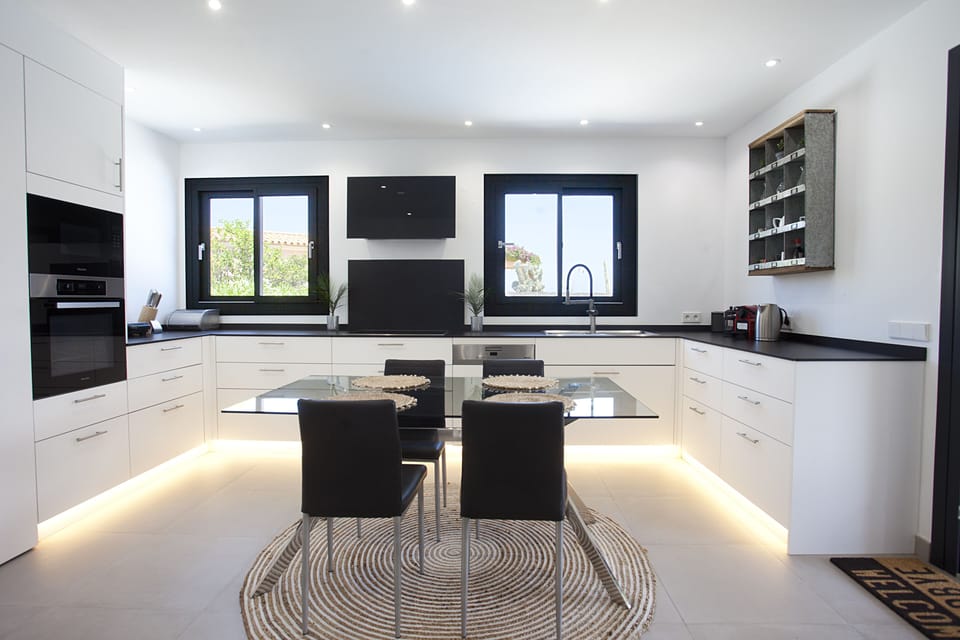 Kitchen area equipped with Miele oven, microwave, stove and dishwasher.