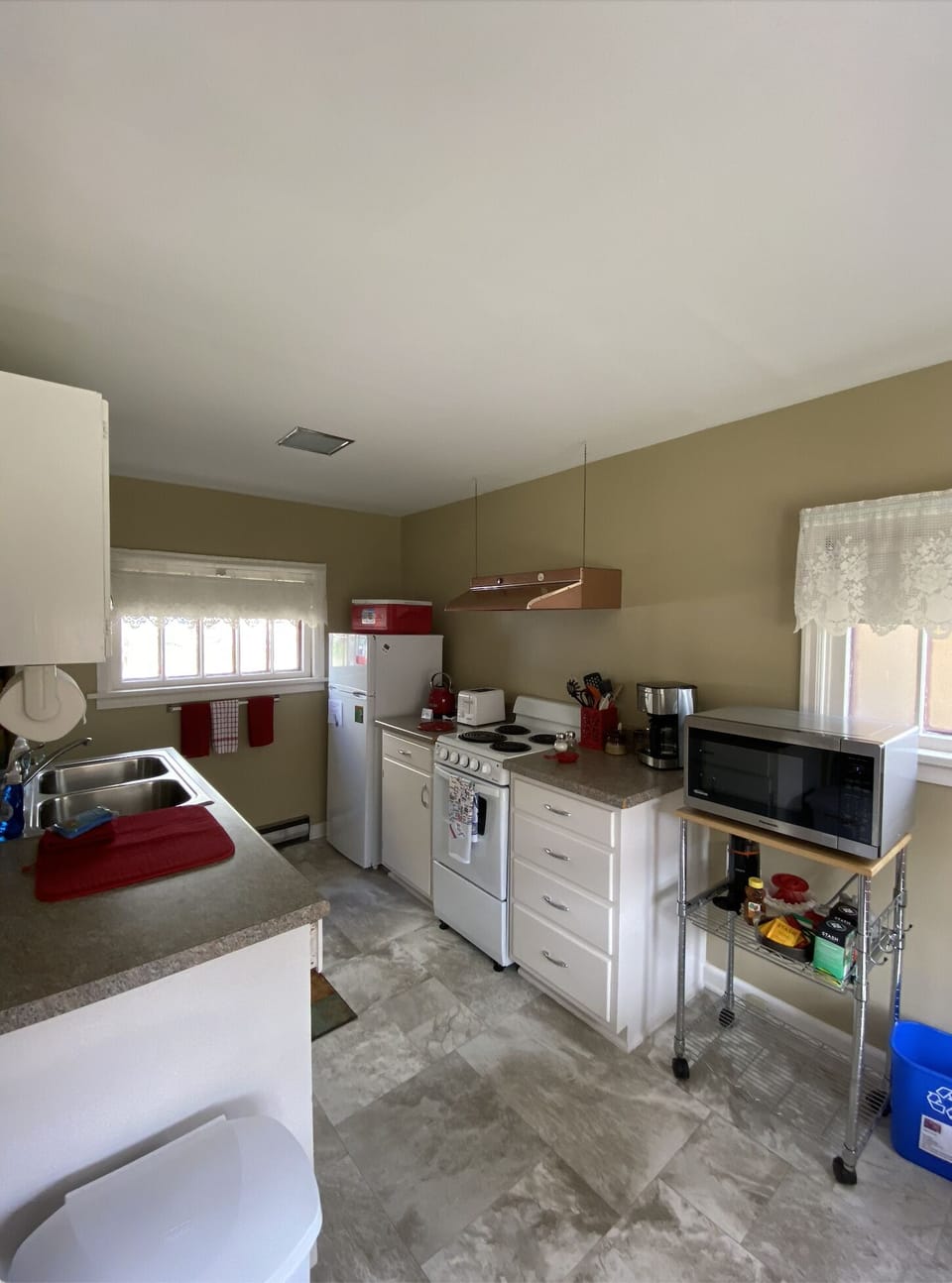 Kitchen has fridge, range, microwave, and other small appliances. 