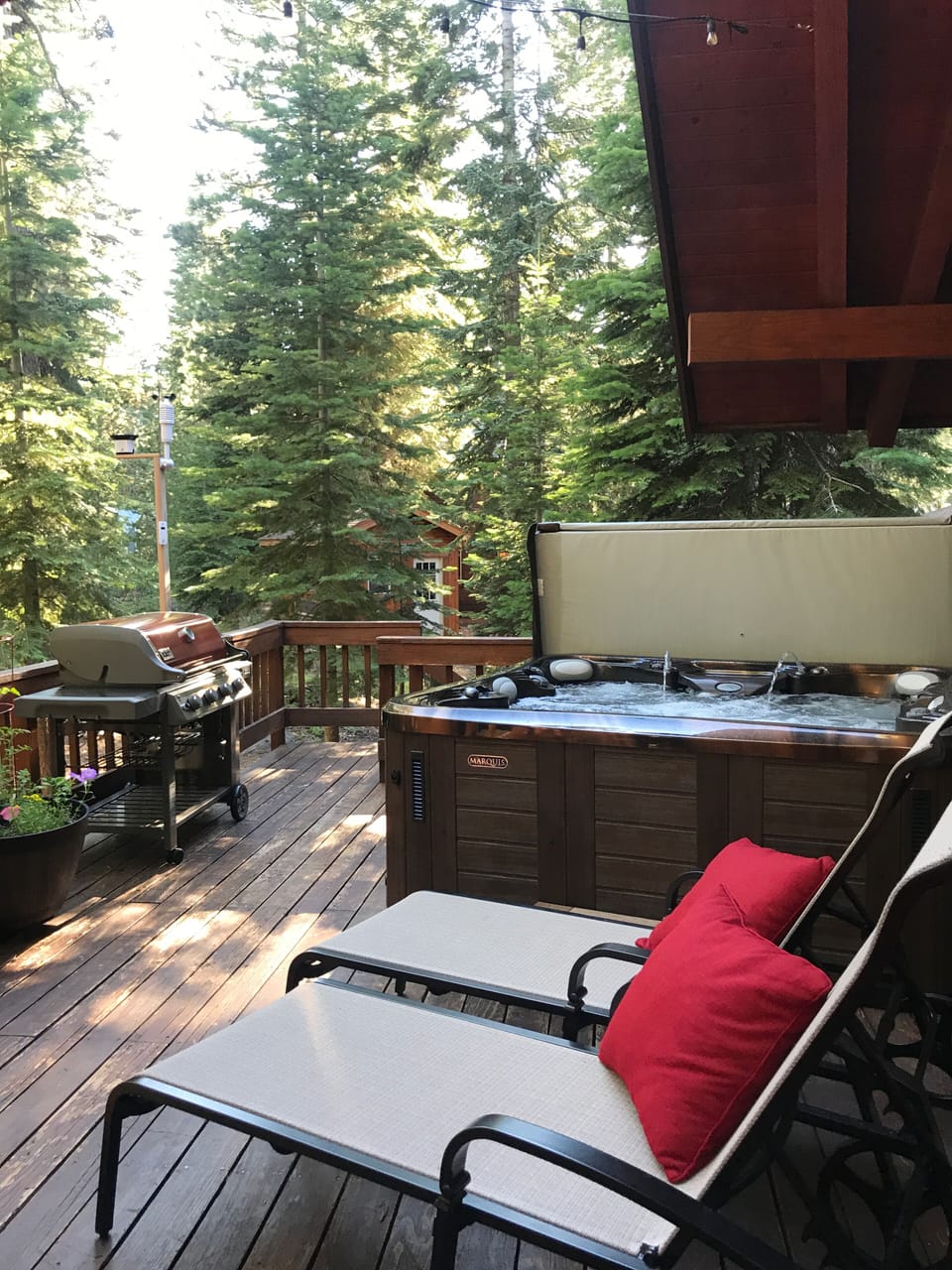 Large back deck with hot tub, chairs for relaxing with plenty of sun and shade.