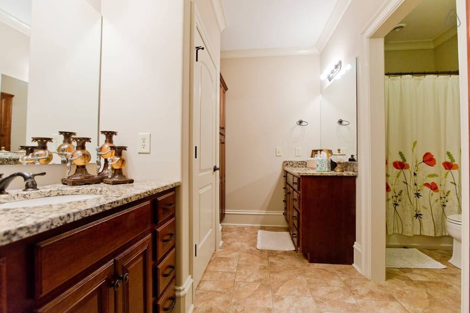 Guest bathroom with double vanities and custom tile shower.