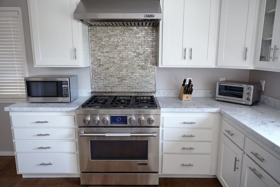 Chef's kitchen with modern appliances and marble countertops
