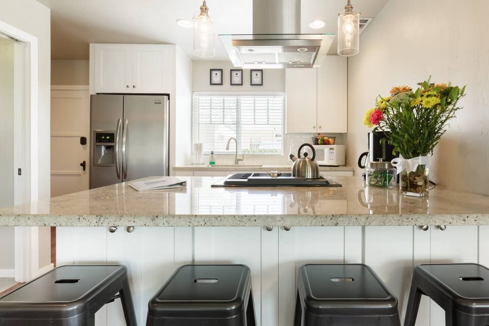 These barstools for 4 are perfect for a meal at the counter or to keep whoever is cooking company! Notice the cupboards behind the barstools... you'll find small appliances and board games!