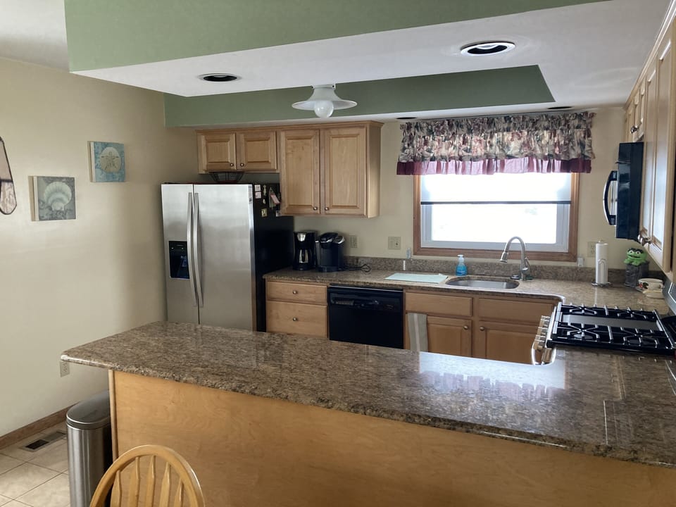 View of kitchen area with modern refrigerator 