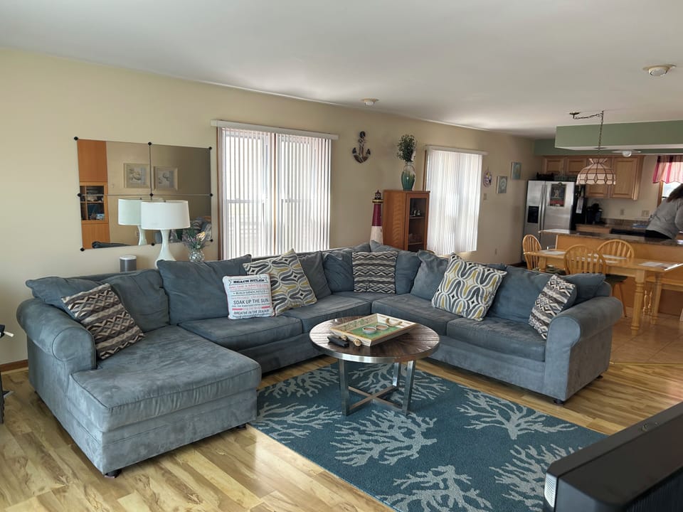 2nd floor family room with 55” television, access to balcony , queen sectional
