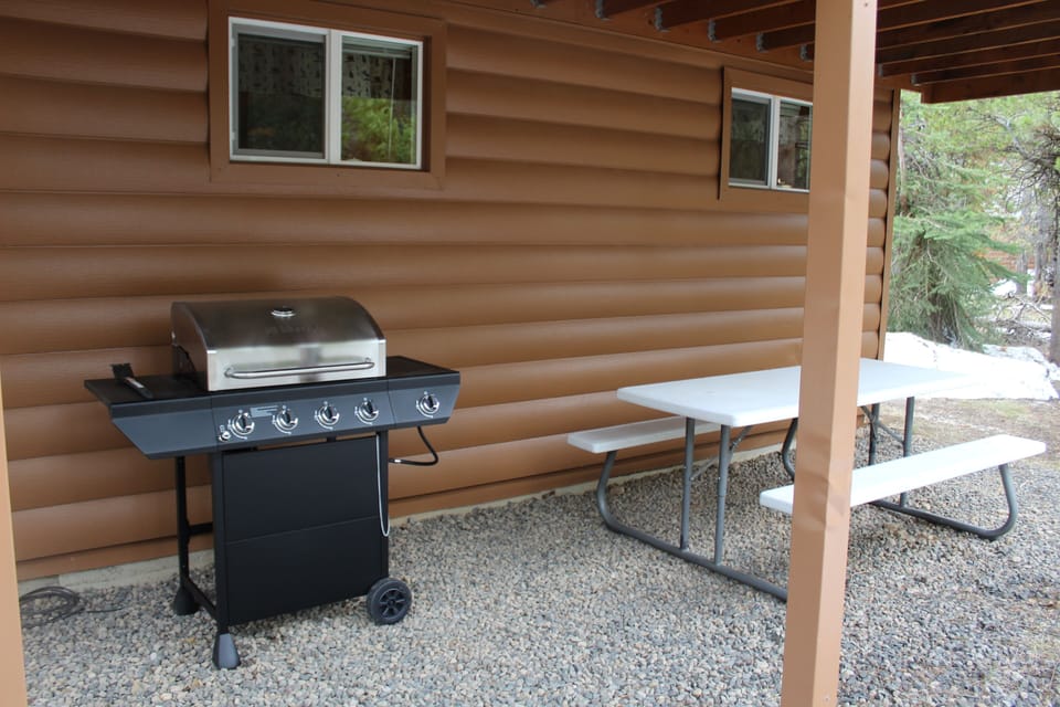 BBQ Grill and table/bench under porch on side of Cozy Cabin