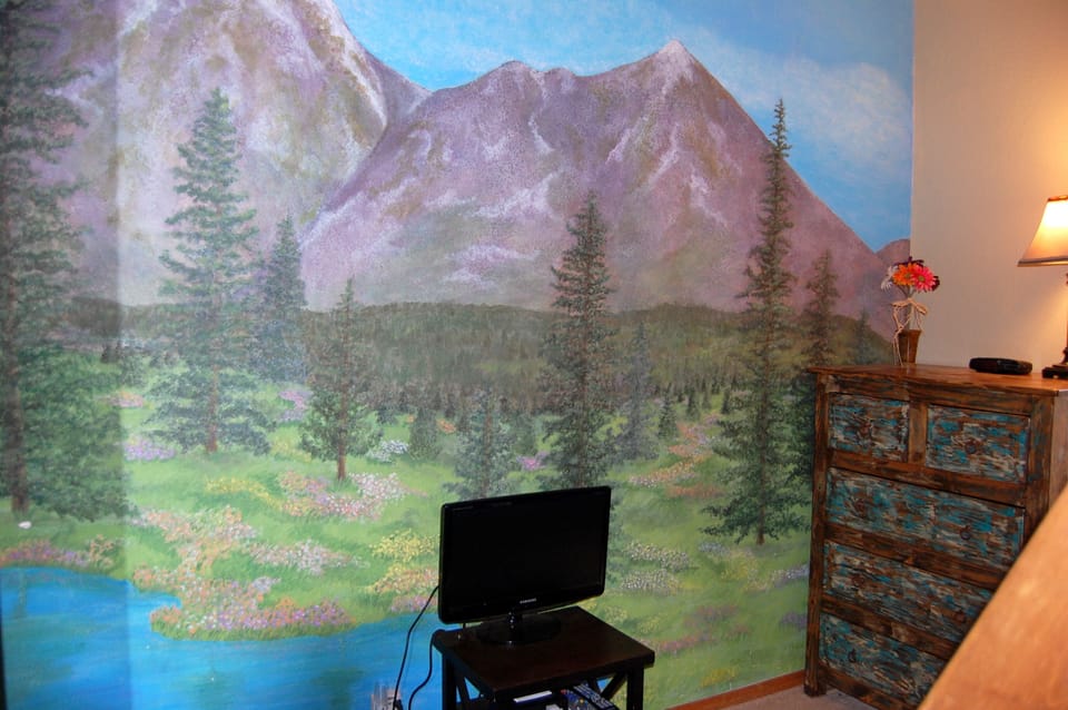 Painted wall mural and TV in bunkbed room