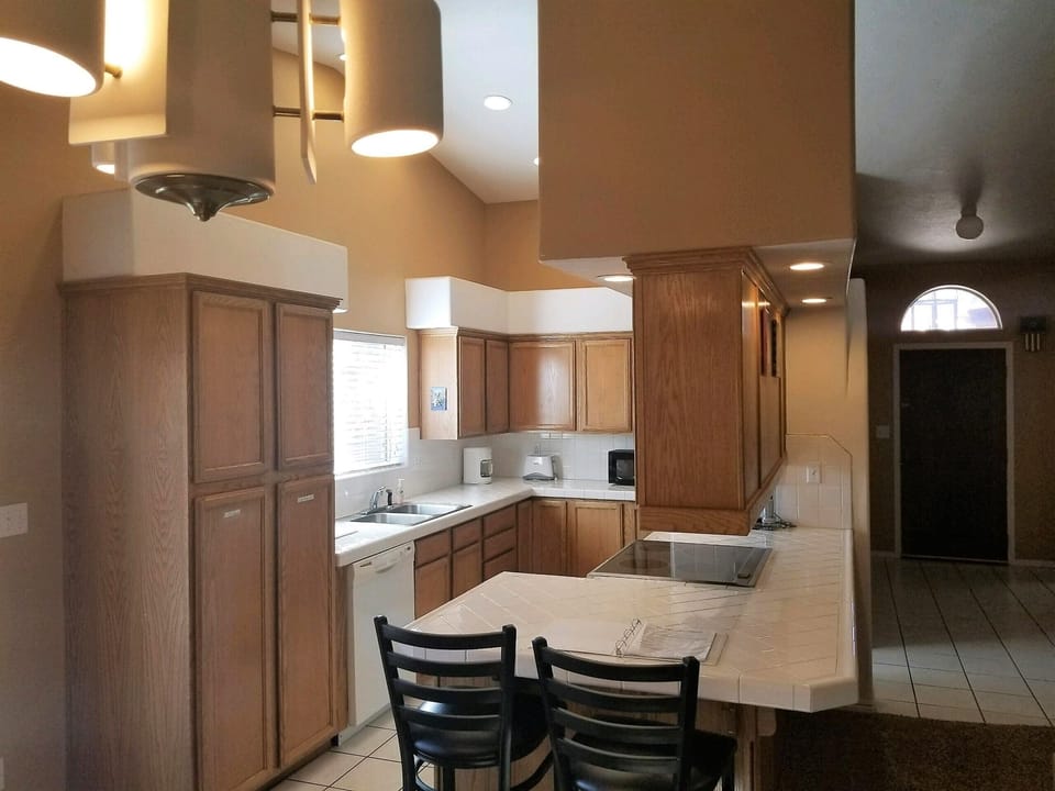 Family style kitchen with open air view of living room and dining area