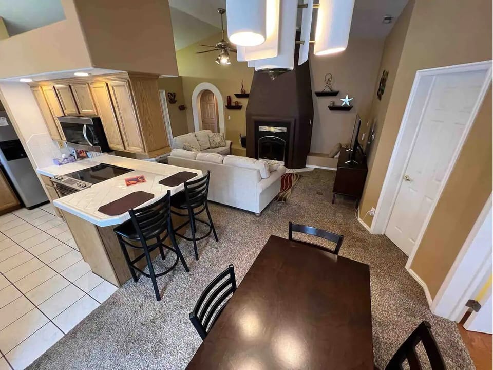 Family style kitchen with open air view of living room and dining area