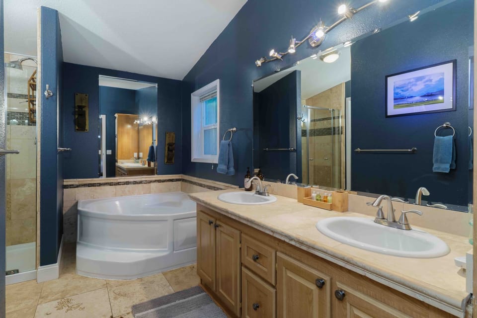 Updated Master Bathroom with Travertine Tile Floors and Vanity.