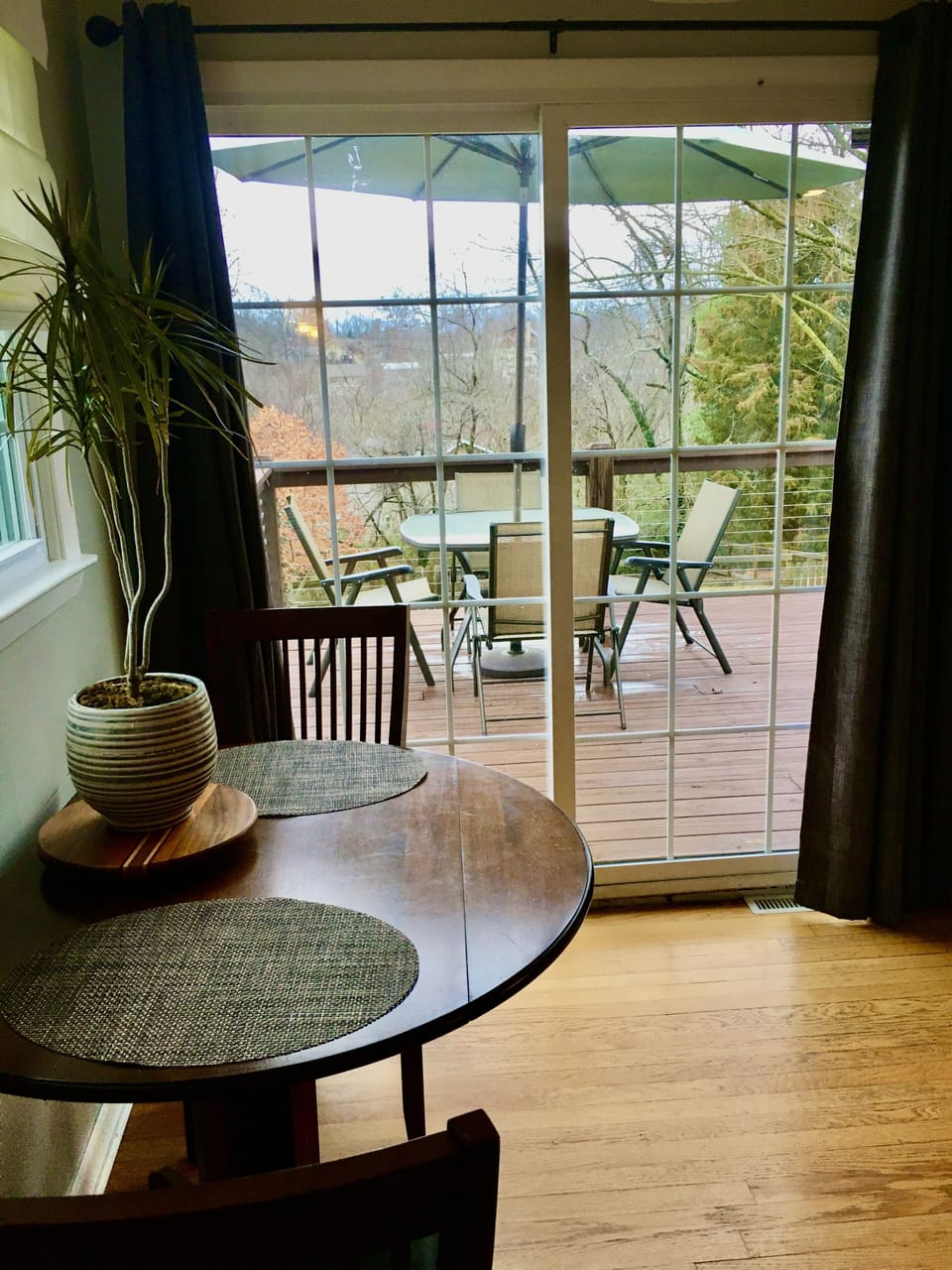 sliding door entering a large back deck with hot tub, table and chairs