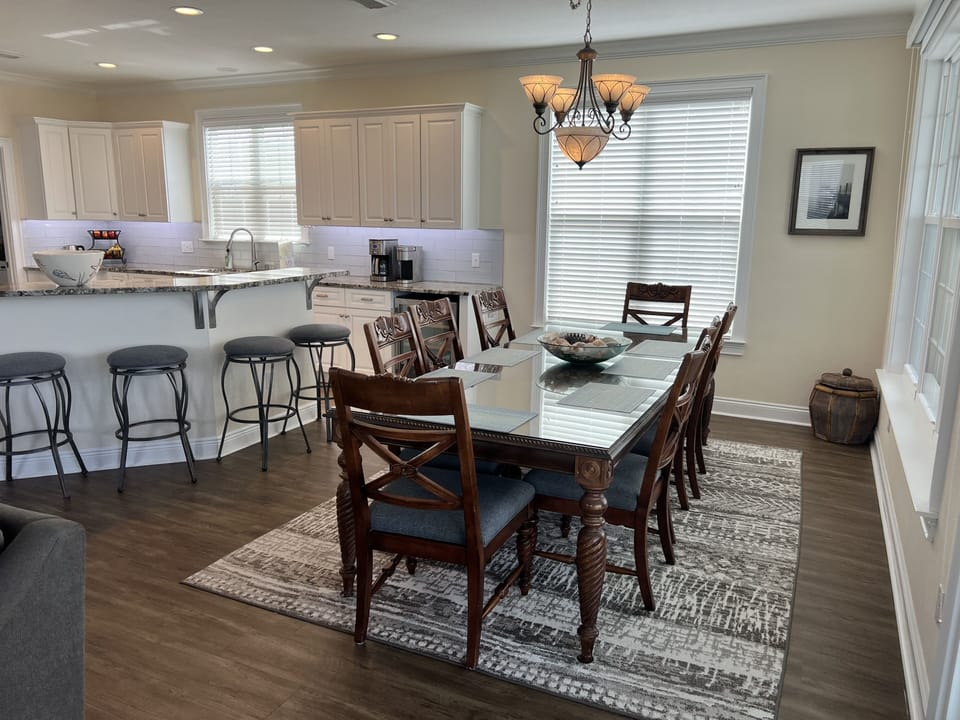 Dining table for 10 with 8 chairs shown, 2 extra folding chairs in laundry room