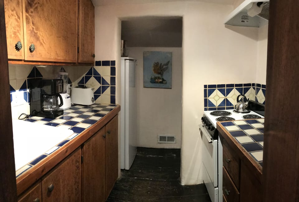 Kitchen features Mexican tiles and stove, fridge, microwave, appliances.