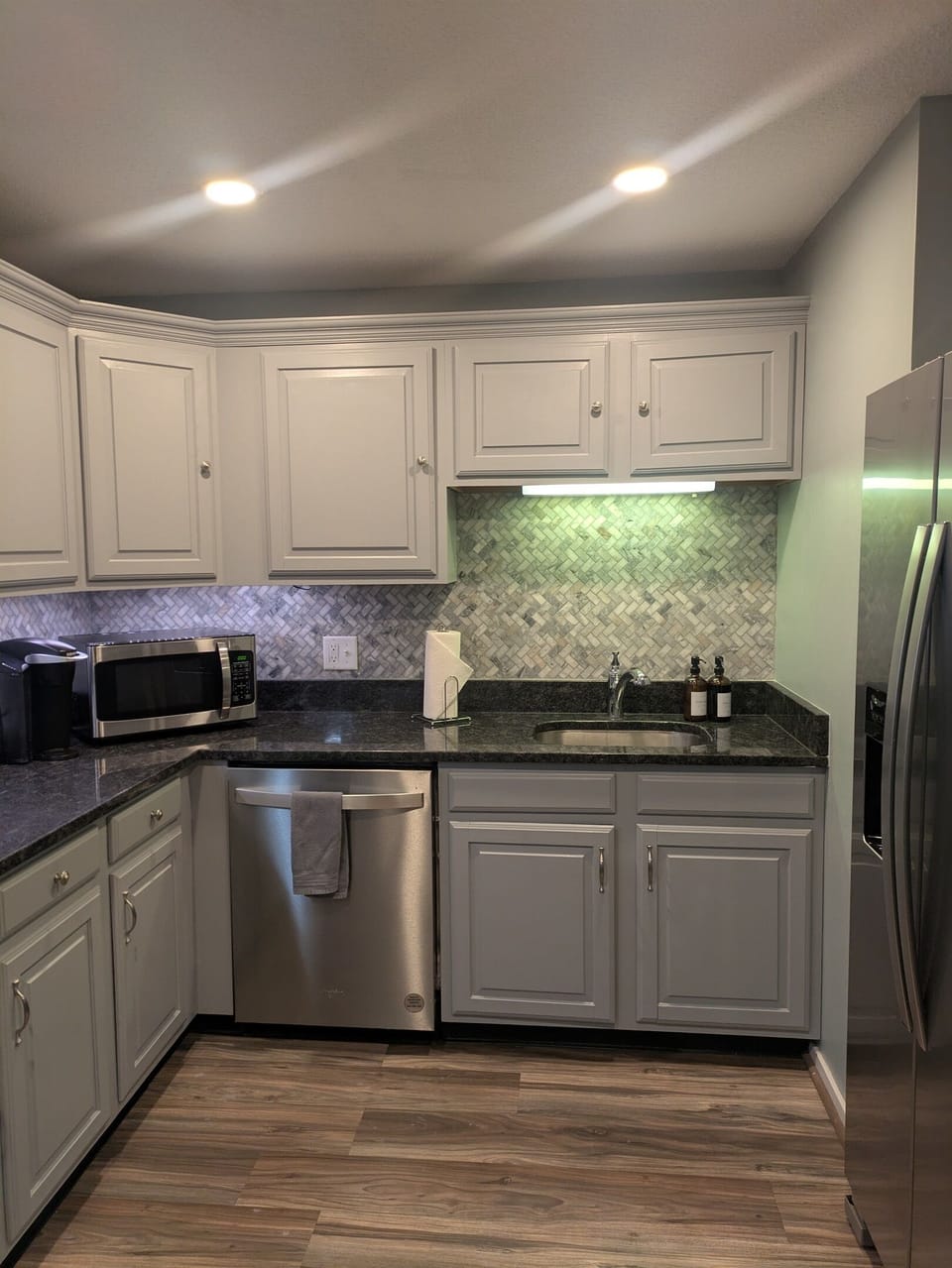 Fully stocked kitchen with granite countertops and stainless-steel appliances. Water and ice machine on fridge.