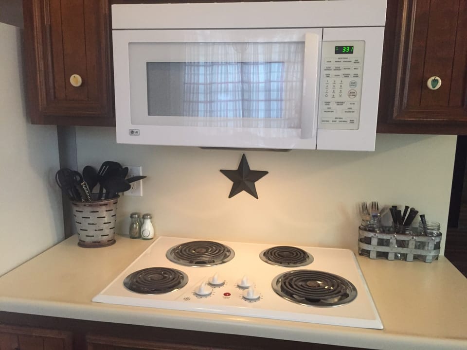 Kitchen with electric cooktop and overhead microwave