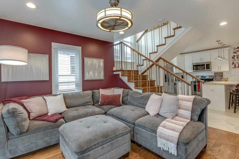 Open-concept living area with staircase and easy flow to kitchen