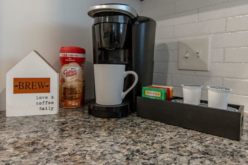 Curated coffee and tea station with Keurig, creamers, and essentials
