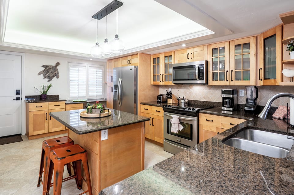 The spacious well-equipped kitchen has an island with bar snack-time seating.