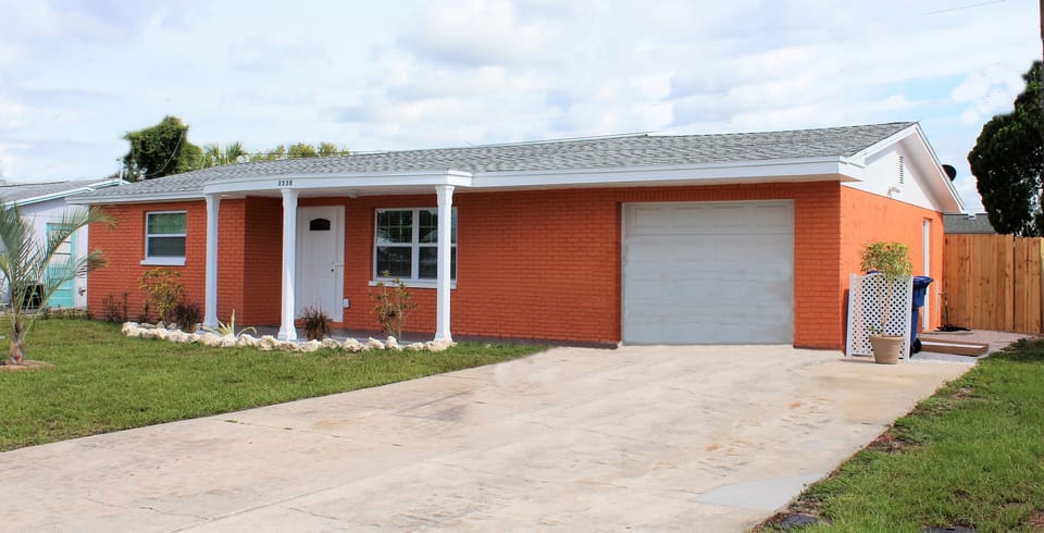 Front of house with driveway and garay view