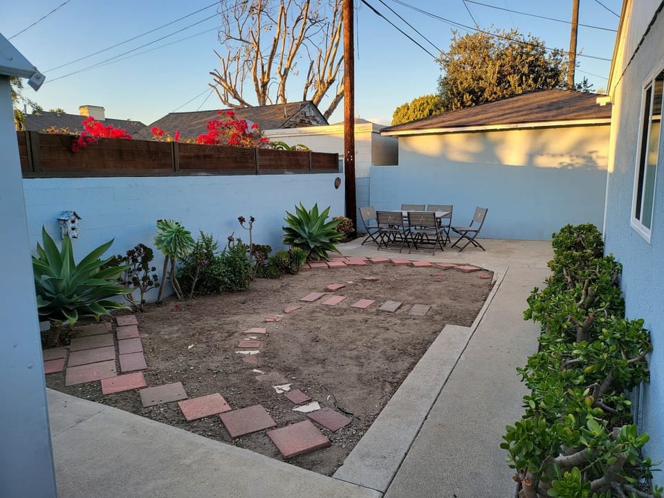 Fully fenced in back yard with outdoor dining table / chairs