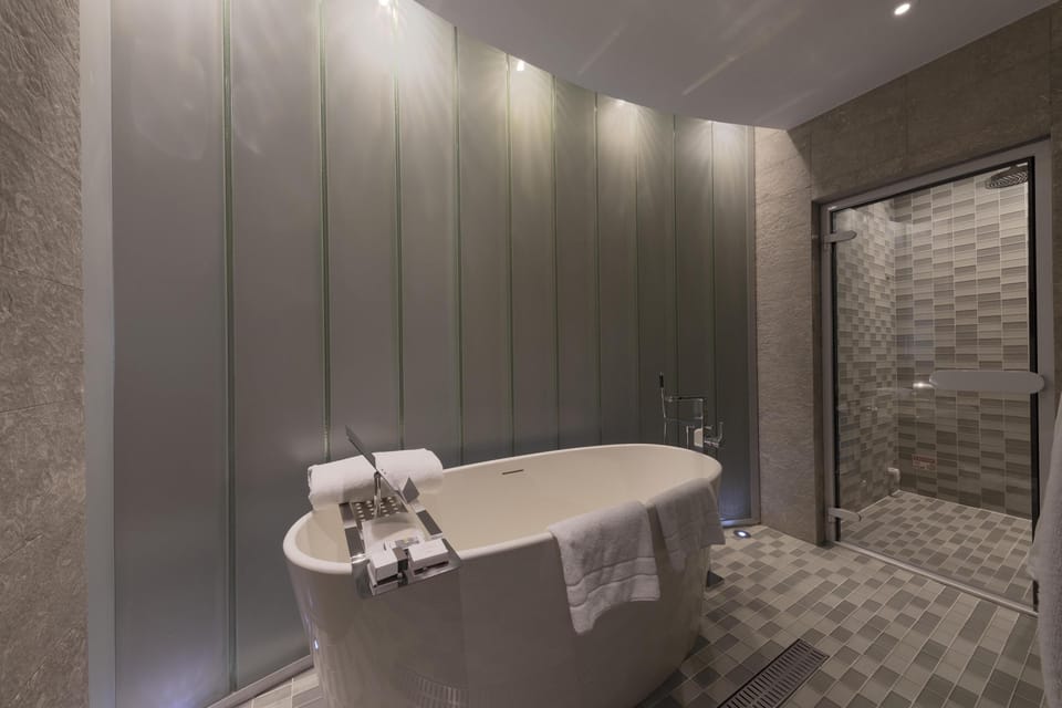 Deluxe Room, 1 King Bed | Bathroom | Separate tub and shower, rainfall showerhead, eco-friendly toiletries