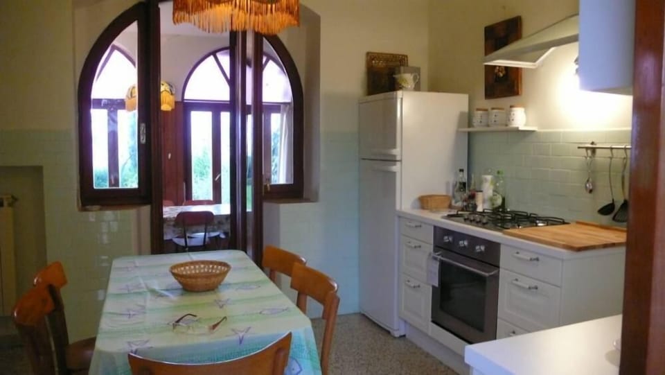 ampia cucina con tavolo centrale e sedie. Completamente arredata ed attrezzata